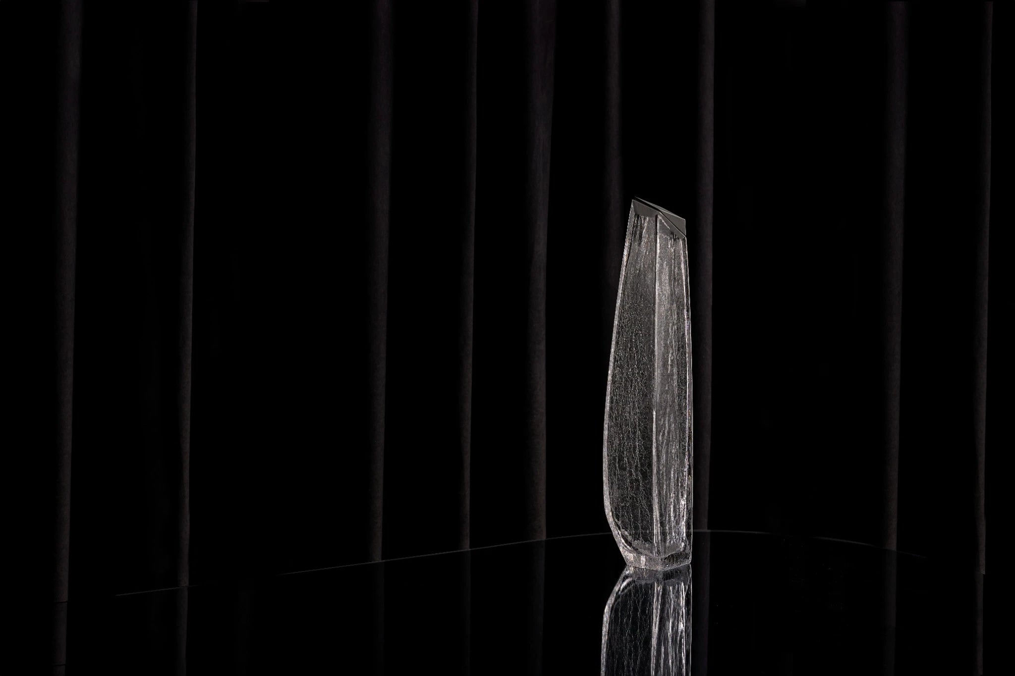 A profile view of the new Raif Whisky Decanter - Crackle Edition shown on a black reflective table surface.