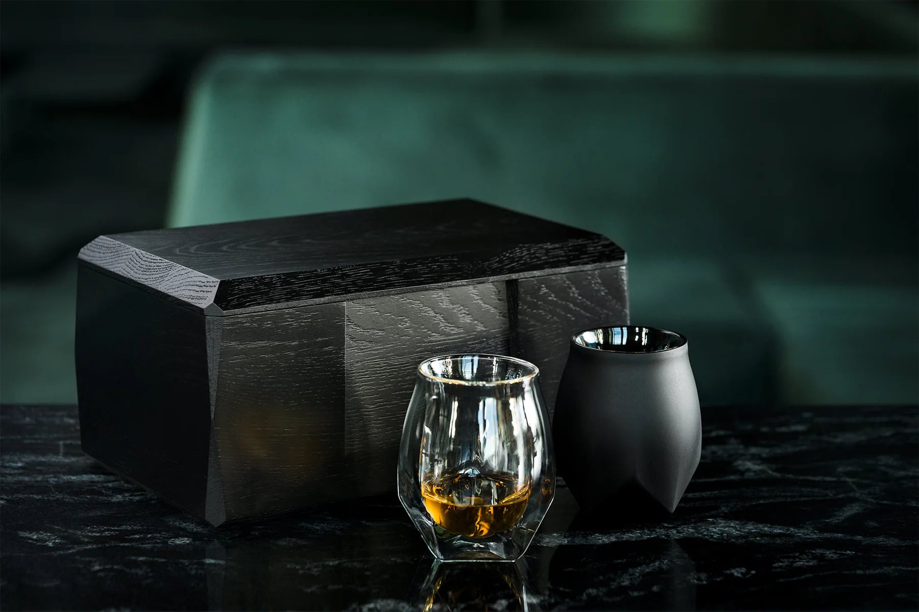 A lifestyle image of the Kist storage case sitting on a black marble table with a clear and VAILD (Black) Norlan Whisky Glass